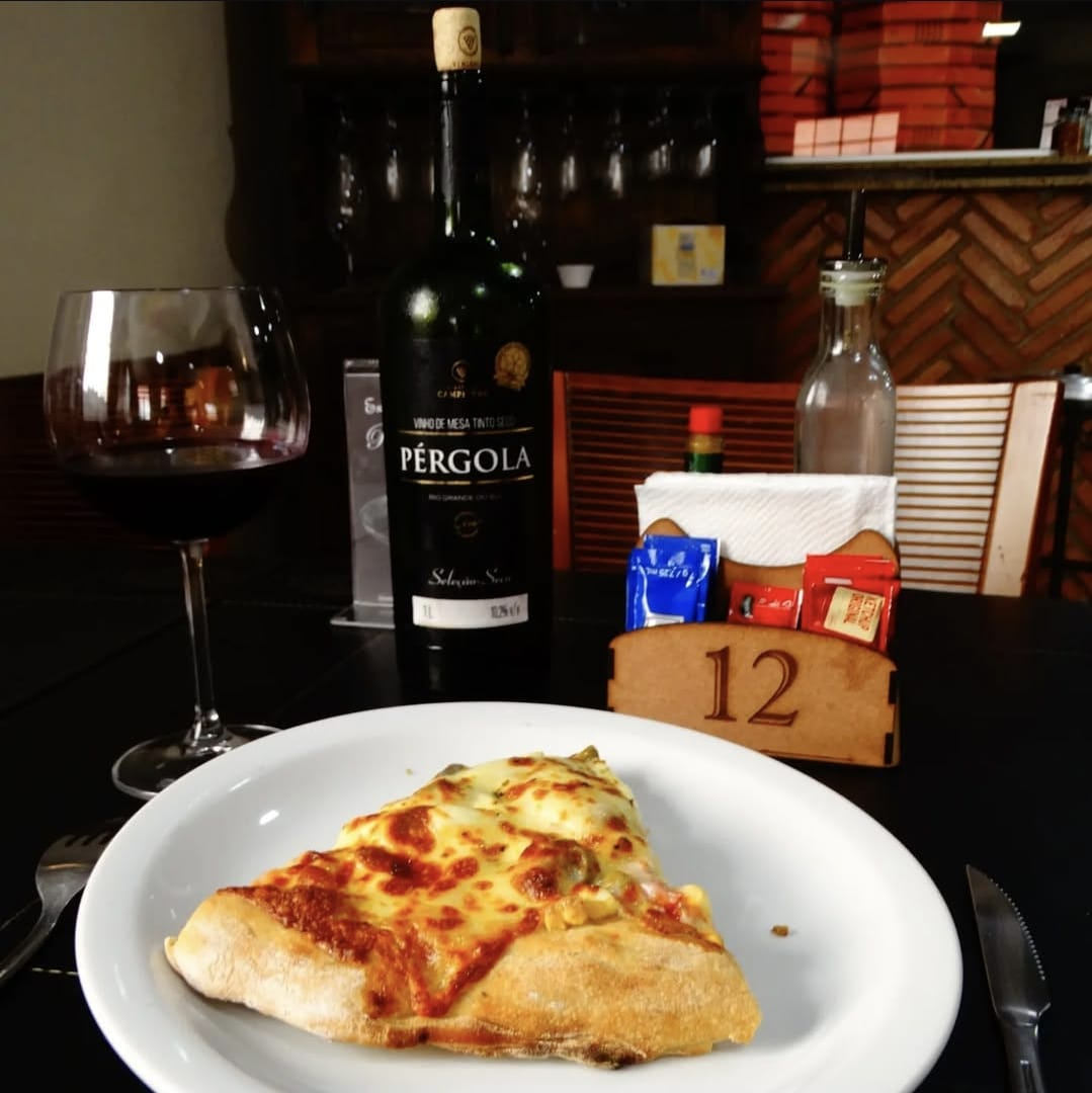 Mesa posta com pizzas e bebidas